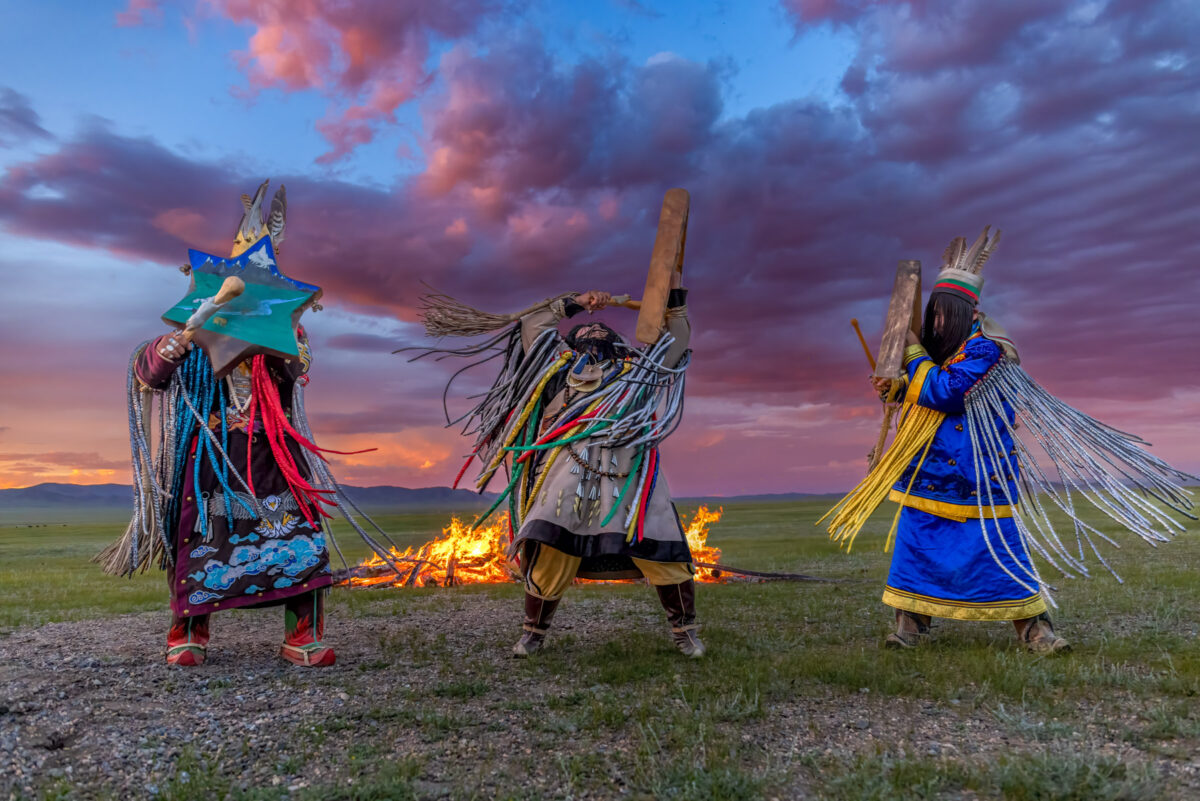 Three shamans engaging in a fire ceremony, Mongolia.